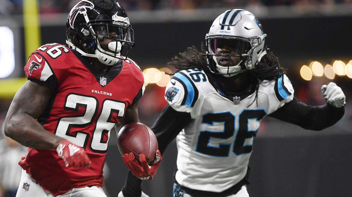 Atlanta Falcons running back Tevin Coleman (26) runs for some of his 107 rushing yards Sunday against the Carolina Panthers and cornerback Donte Jackson (26) in Atlanta. Coleman broke the Panthers’ 21-game streak without allowing a 100-yard rusher.