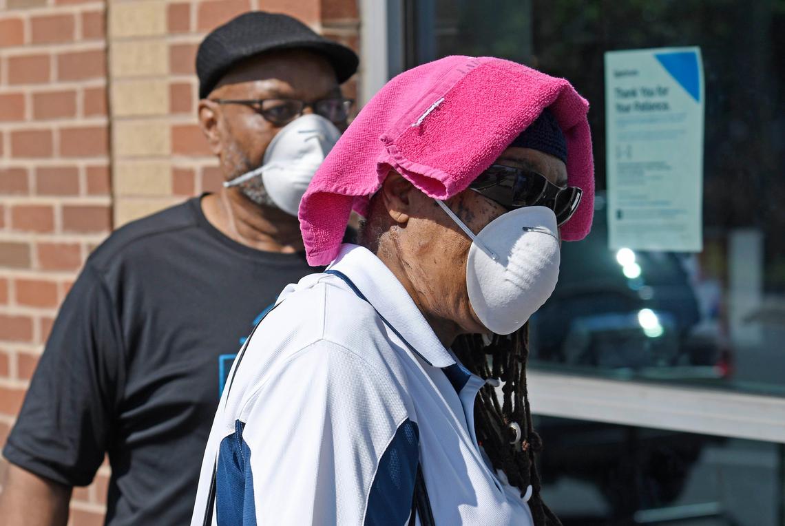 Mecklenburg County is considering a mask mandate amid rising cases of COVID-19 locally. Shown here, Customers line up wearing masks outside the Spectrum store on South Boulevard in Charlotte.