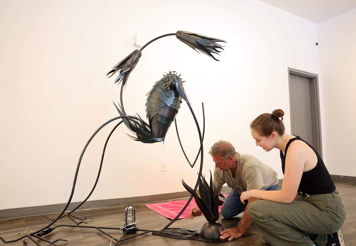 Artist Randy Weiss, left, and Annie Heisel, Center for the Arts gallery manager, install a sculpture at the center. Federal funding cuts for the arts haven’t significantly impacted Rock Hill.