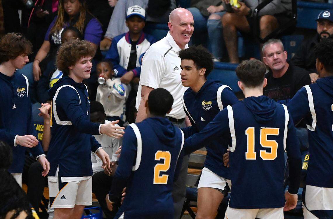 East Meck head coach Jason Buzzard smiles as his son, Jordan Buzzard, center and team are introduced prior to action against Rocky River on Friday, January 26, 2024 at East Meck High. Rocky River defeated East Meck 66-57.