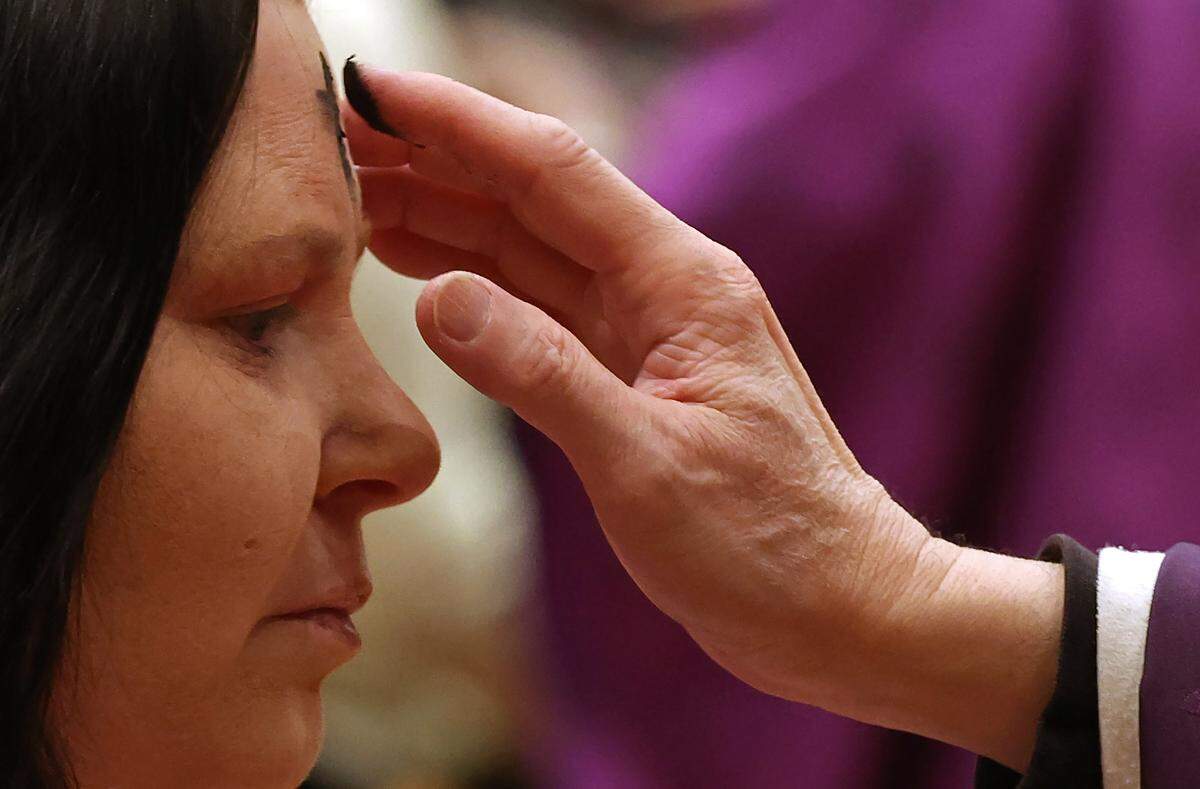 Bishop Michael Martin, right, applies ashes to the forehead of a parishioner during an Ash Wednesday Mass at St. John Neumann Catholic Church in Charlotte, NC on Wednesday, February 18, 2026. Bishop Michael Martin is laying out his vision for the church and some of his initial actions have faced scrutiny. 