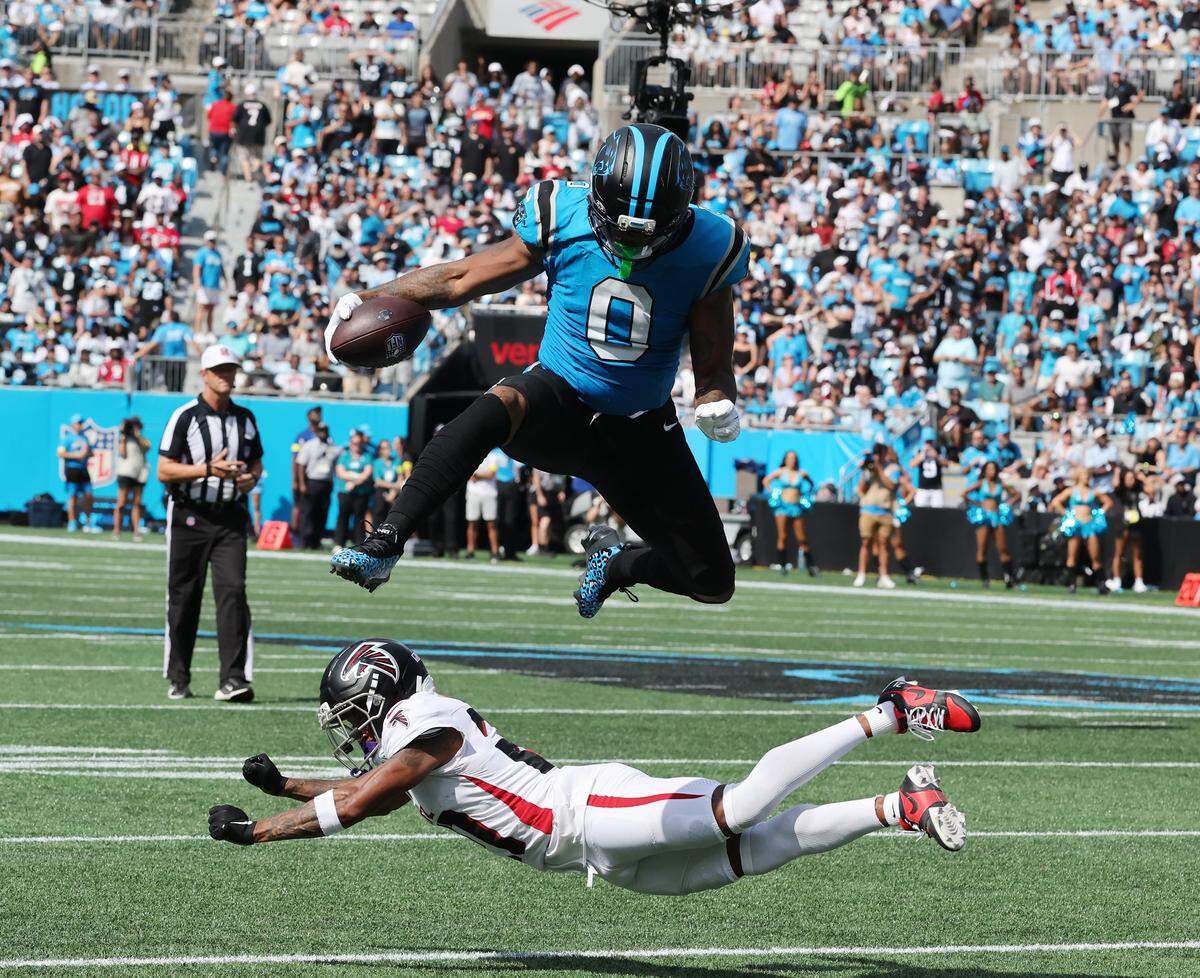 Carolina Panthers Ja'Tavion Sanders leaps over Atlanta F’alcons Mike Hughes at the Bank of America Stadium in Charlotte on Sunday, September 21, 2025.