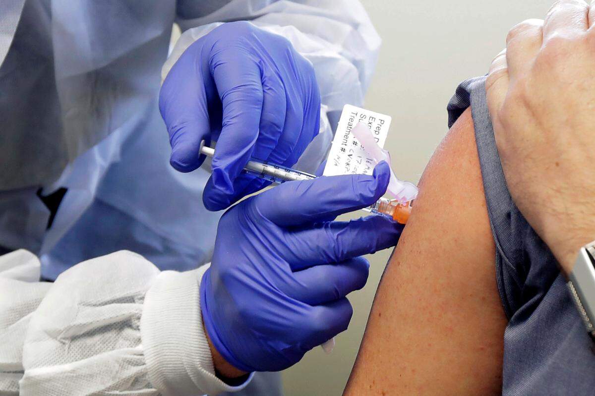 FILE - A patient receives the first-stage safety study of a potential vaccine for COVID-19 at the Kaiser Permanente Washington Health Research Institute in Seattle last March. Moderna Inc., and Pfizer have announced their COVID-19 vaccines are proving to be highly effective in a major trials. (AP Photo/Ted S. Warren, File)