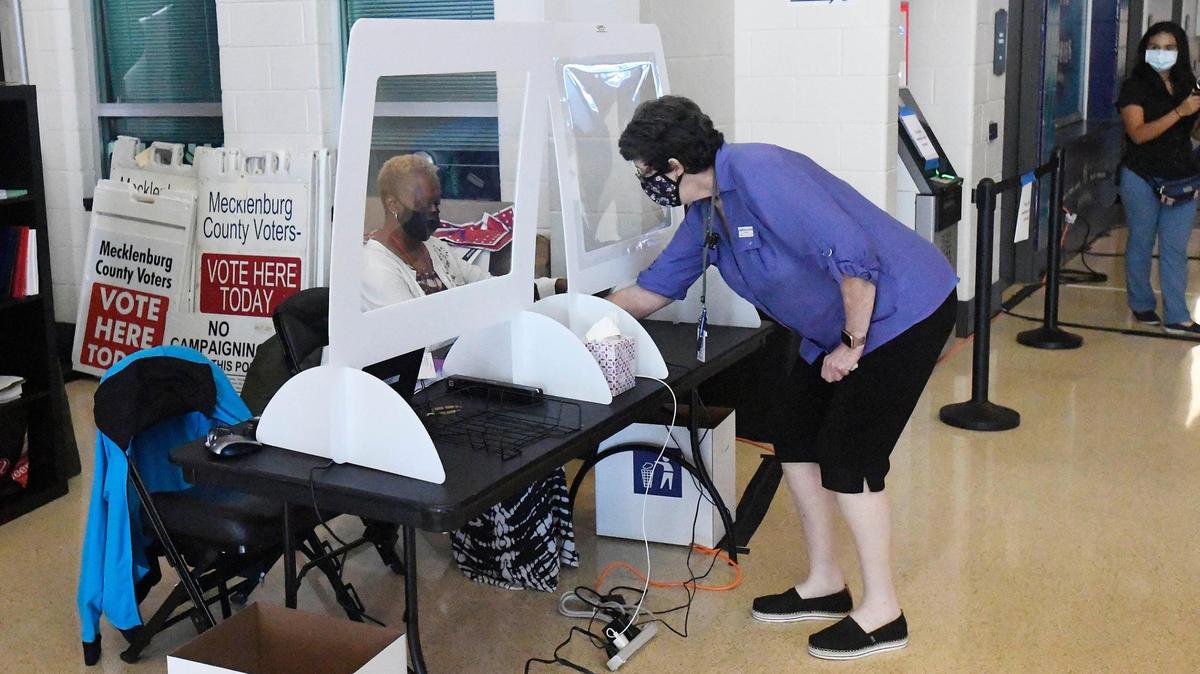 This was the scene inside the Spectrum Center Thursday before the start of Early Voting as two poll workers readied a check-in station. The State Board of Elections requires poll workers to wear masks. Voters are “strongly encouraged,” but not required to wear them. 