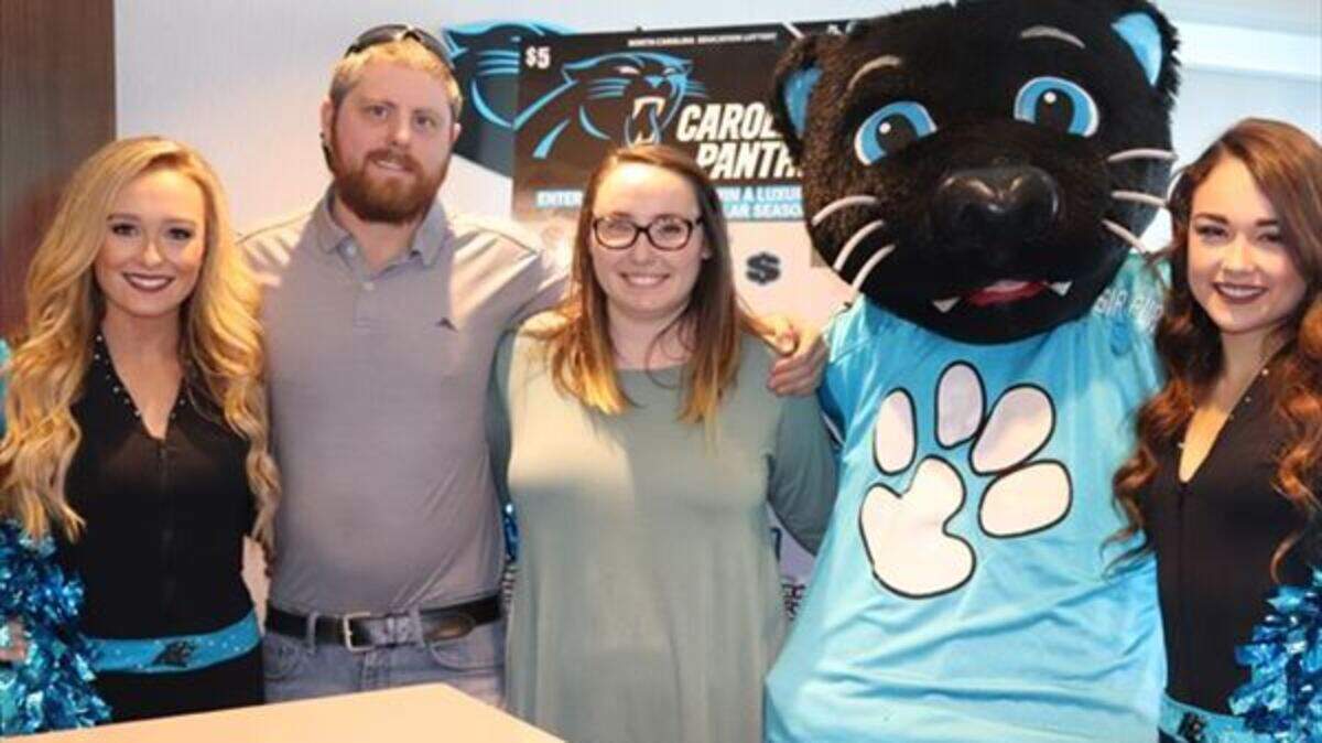 Longtime Carolina Panthers’ fan Jasmine Maloy of Charlotte, third from left, won a 2019 luxury suite for 12 through the NC Education Lottery.