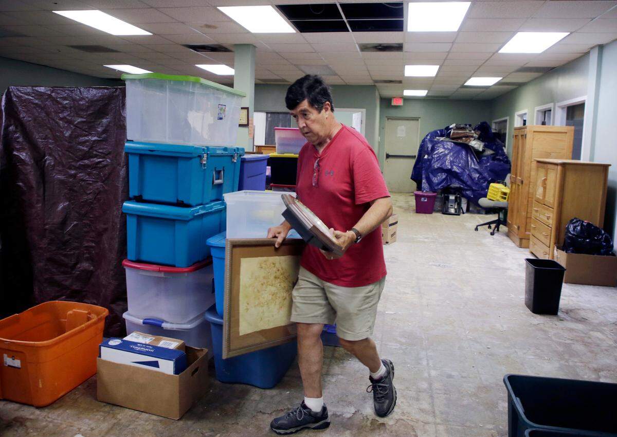 Knights of Columbus volunteer Vince Williams carries a wall hanging to be stored Friday at Family Promise of York County. The homeless shelter has sustained damage to its roof after a May hail storm.