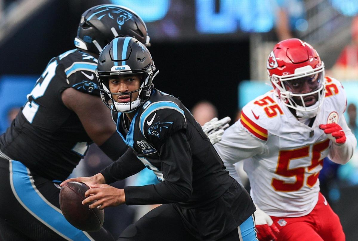 Panthers quarterback Bryce Young scans the field for a pass as Chiefs defensive end Joshua Uche persues during the game at Bank of America Stadium in Charlotte, NC on Sunday, November 24, 2024.