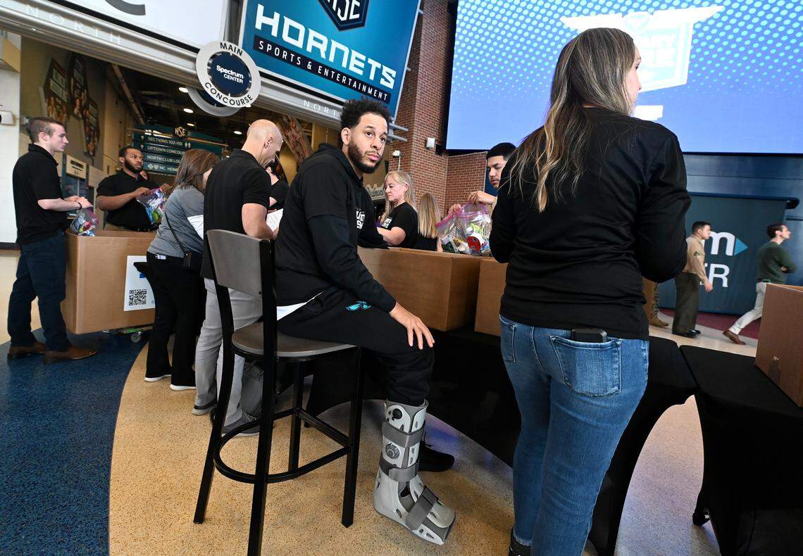 Charlotte Hornets guard Seth Curry, center, wears a walking boot on his right leg during the team and Novant Health’s Military Care event at Spectrum Center on Monday, March 4, 2024.