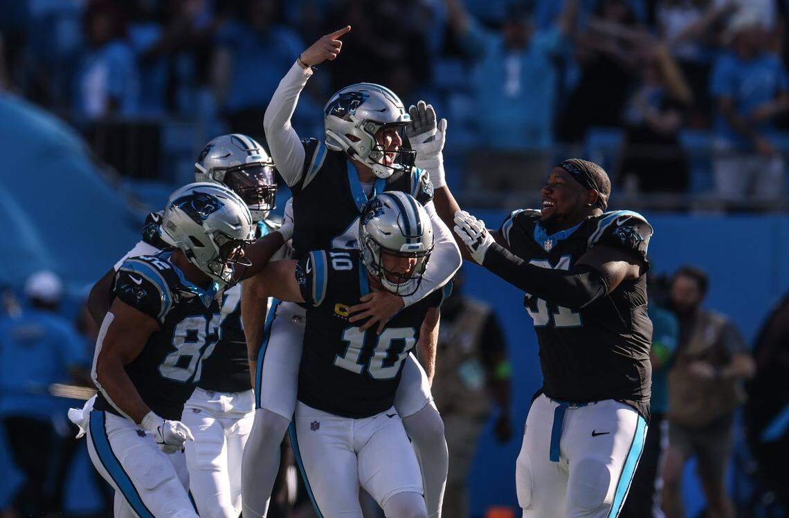 Players celebrate Carolina Panthers placekicker Eddy Pineiro’s game-winning field goal at the Bank of America Stadium in Charlotte, N.C., on Sunday, October 29, 2023, that beat the Houston Texans, 15-13. Pineiro is riding on the back of punter Johnny Hekker (10), who was also the holder for the game-winning, 23-yard field goal that Pineiro made as time expired.