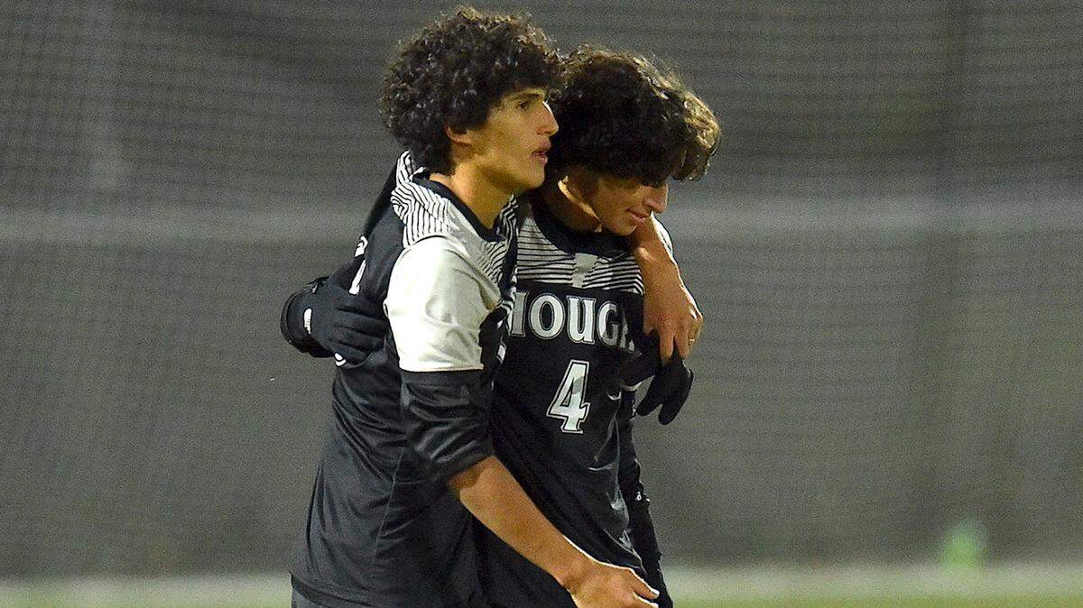 Hough’s Antonio Lagua (4) and Eugenio de la Parra Polina (10) embrace after their loss to New Hanover in the NCHSAA4A Boys Soccer Championship. The New Hanover Wildcats and the Hough Huskies met in the NCHSAA 4A Boys Soccer Championships in Cary, N.C. on November 20, 2021.