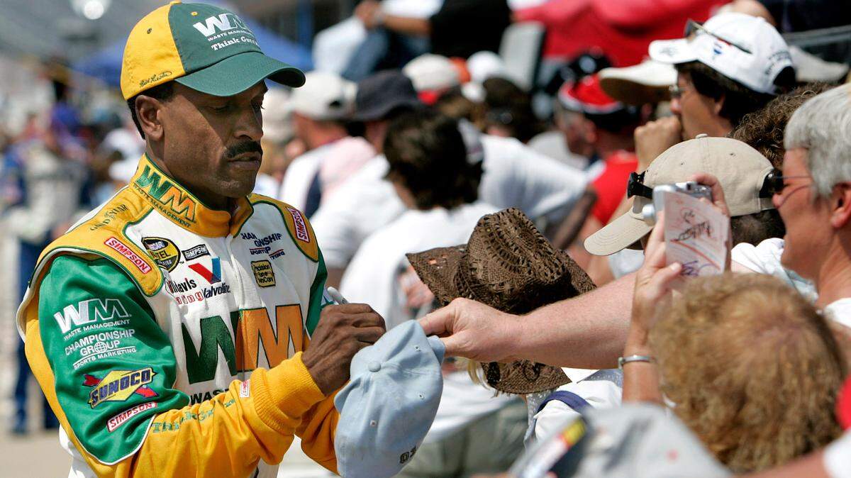 Bill Lester signs autographs prior to qualifying for the NASCAR Nextel Cup 3M Performance 400 at Michigan International Speedway in Brooklyn, Mich., Friday, June 16, 2006. Lester, the first black driver to race in NASCAR’s top stock car series in 20 years, backed up his solid qualifying run in March at Atlanta with another strong performance qualifying 34th. (AP Photo/Paul Sancya)
