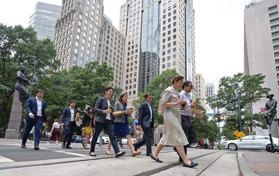 Uptown workers cross Tryon Street at Trade Street in Charlotte on Wednesday, June 30, 2021. Expect to see lots more workers slowly coming back to uptown offices.