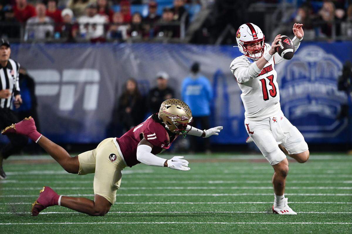 Dec 2, 2023; Charlotte, NC, USA; Louisville Cardinals quarterback Jack Plummer (13) evades a tackle by Florida State Seminoles defensive lineman Patrick Payton (11) in the first quarter at Bank of America Stadium.
