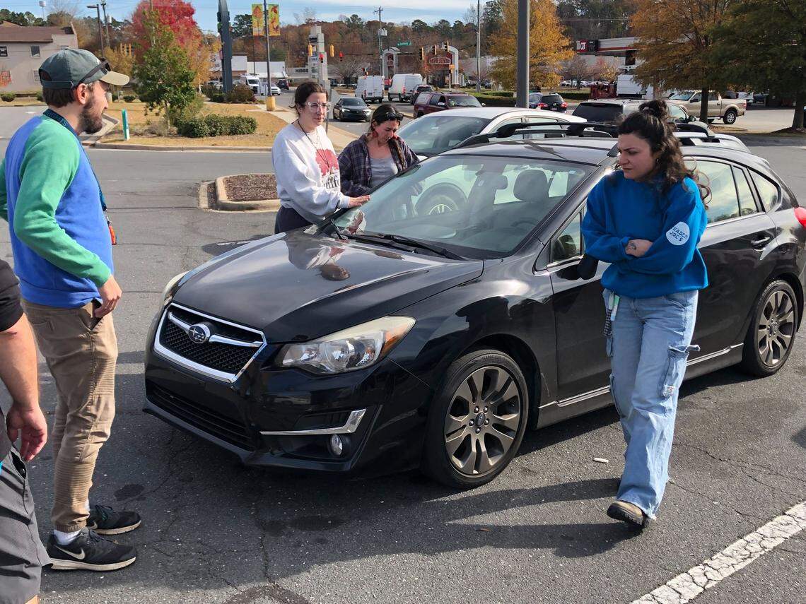Local volunteers stand near the car of Joshua Long, who was documenting U.S. Border Patrol and was arrested by agents at the Eastway Crossing Shopping Center in Charlotte on Tuesday, November 18, 2025.