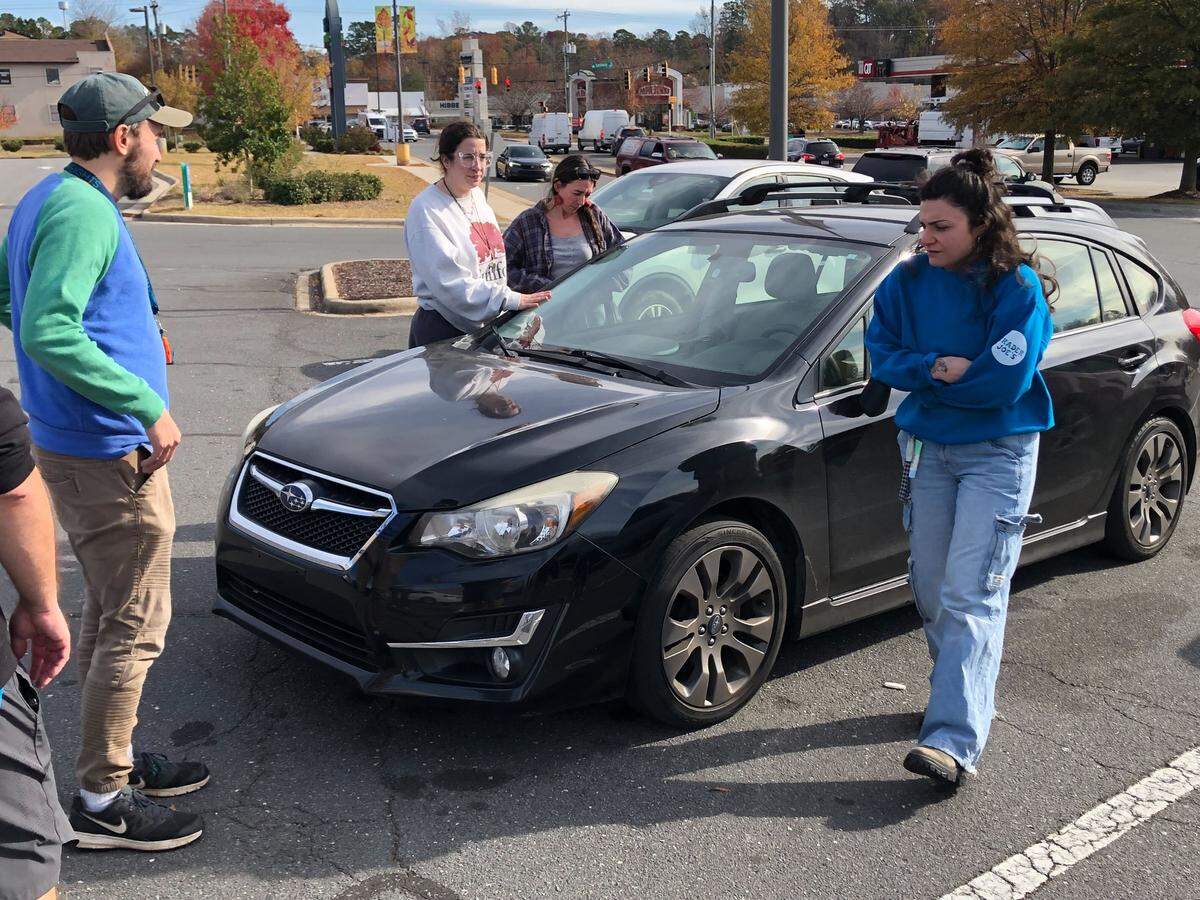 Local volunteers stand near the car of Joshua Long, who was arrested by U.S. Border Patrol agents at the Eastway Crossing shopping center on Eastway Drive in Charlotte on Tuesday, November 18, 2025.