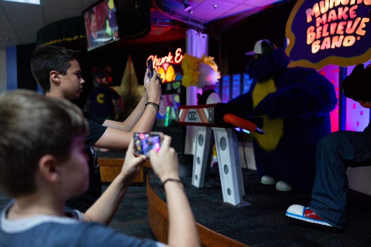 Oliver Zepsa, 14, back, and his brother, Dominic, 12, take photos of Munch’s Make Believe Band at Chuck E. Cheese in Charlotte, N.C., on Friday, May 31, 2024. Oliver and Dominic are animatronics enthusiasts and came to see the animatronics once they heard the news that this location would be one of the five being saved in the U.S.