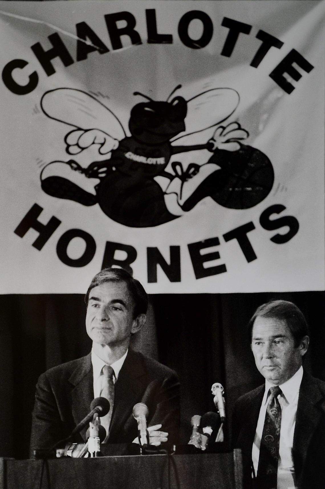 Former Charlotte Hornets GM Carl Scheer (left) and team owner George Shinn stand under the Hornets banner and answer questions concerning Scheer’s resignation, which came after Shinn wouldn’t offer him a multi-year contract. The two men later would work together again and renew their friendship.