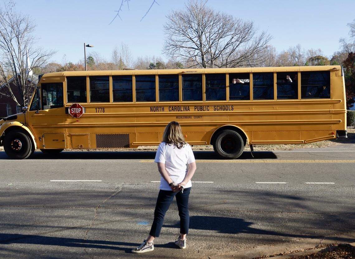 Concerned adults gather at a bus stop to help ensure kids get off the school bus safely in the Berryhill area.