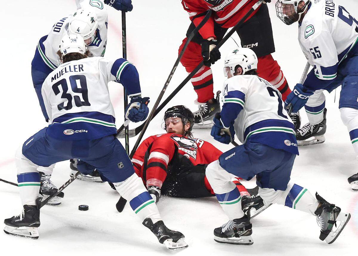 Charlotte Checkers Rasmus Asplund, center, is unable to strike the puck from his back as the Abbotsford Canucks swarm during Game 6 of Monday’s Calder Cup finals at Bojangles Coliseum. The Canucks defeated the Checkers 3-2 to win the Calder Cup.