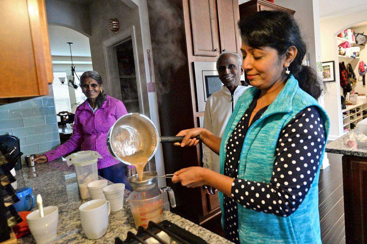 Nidiya Gaspar prepares chai as her mother, Nirmala Michael, far left and father Lourdu Susai, center, watch. The Gaspar family is one of millions of multigenerational households in the United States.