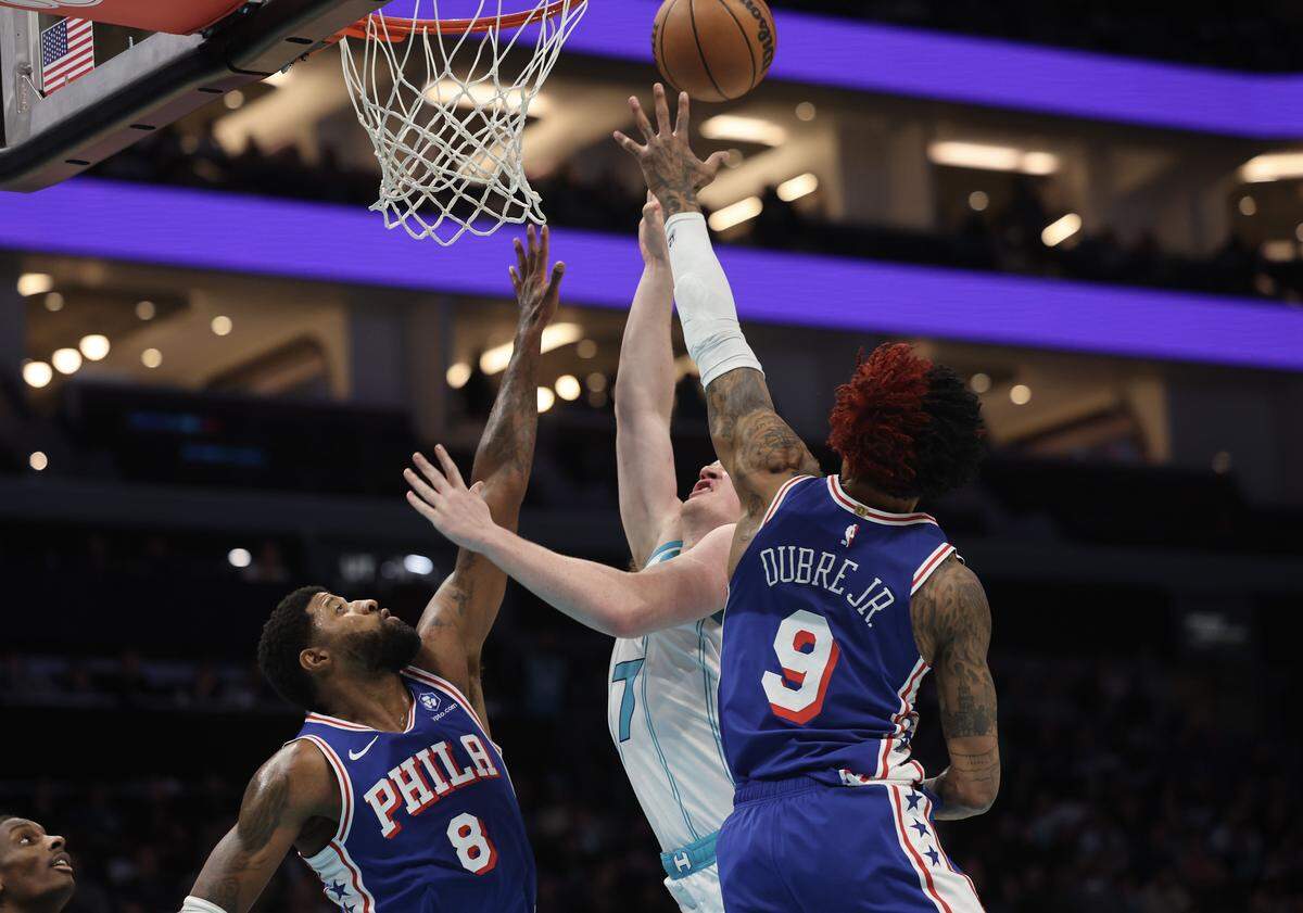 Charlotte Hornets forward Kon Knueppel's shot is blocked by Philadelphia 76ers Paul George (8) and Kelly Oubre Jr. at the game Saturday, March 28, 2026 at Spectrum Center in Charlotte.