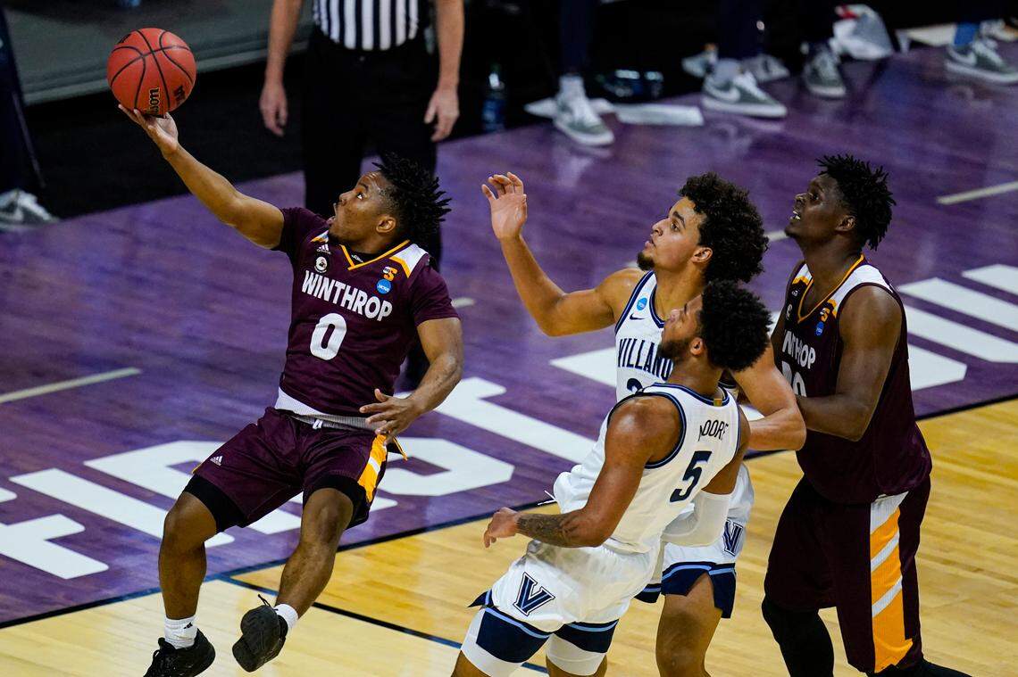 Winthrop guard Russell Jones Jr. (0) shoots in front of Villanova forward Jeremiah Robinson-Earl (24) and guard Justin Moore (5) in the first half of a first round game in the NCAA men’s college basketball tournament at Farmers Coliseum in Indianapolis, Friday, March 19, 2021. (AP Photo/Michael Conroy)
