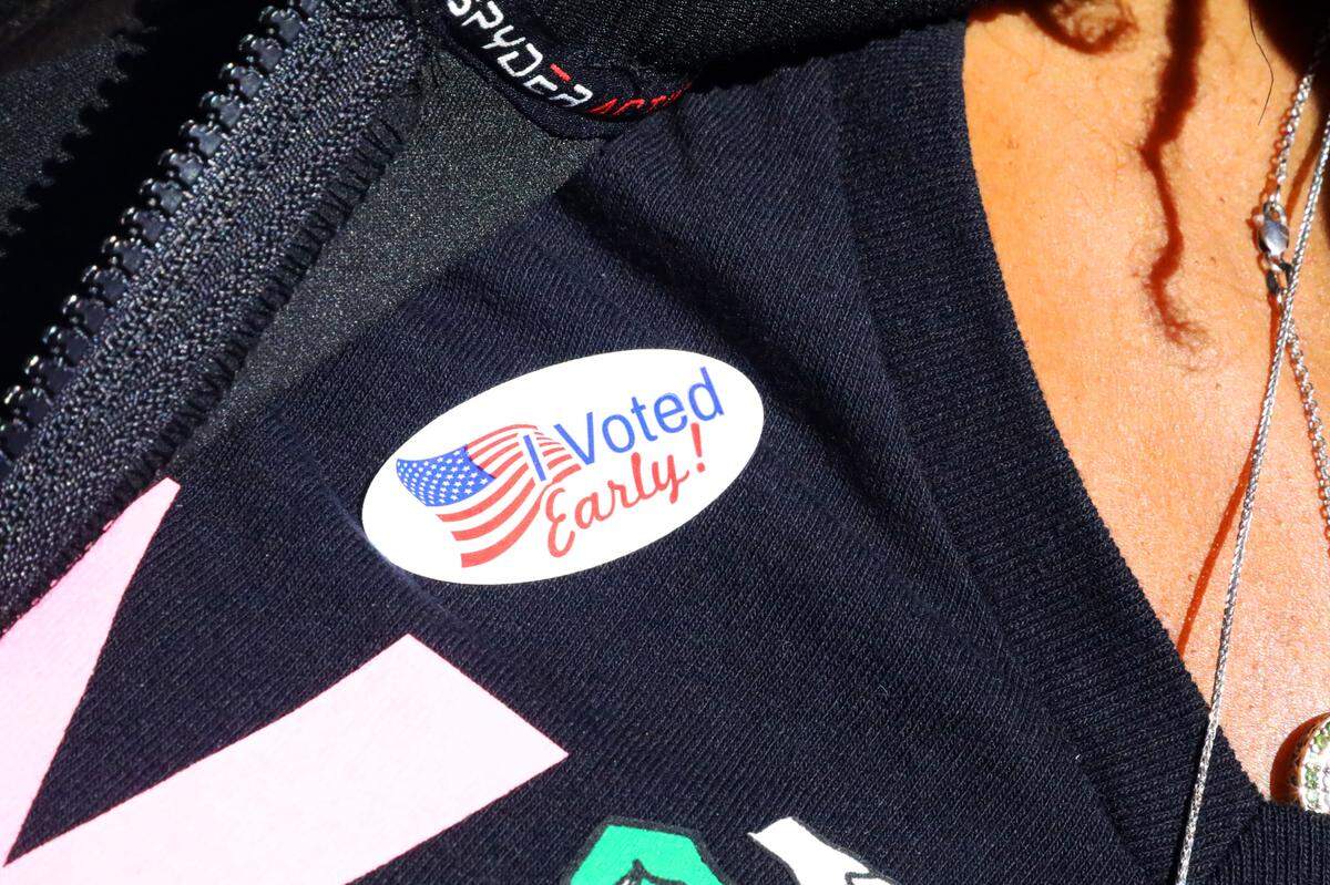 An early voter sports a sticker after casting her ballot at the Allegra Westbrooks Regional Library in Charlotte, N.C., on October 17, 2024.