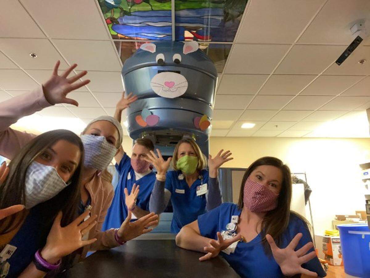 Medical workers show off some of the masks that Children’s Theatre of Charlotte made for Novant Health.