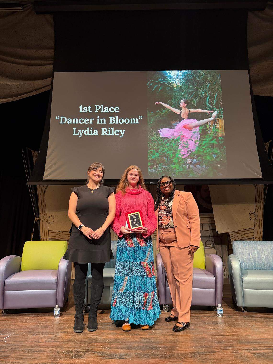 Lydia Riley, center, a student at East Mecklenburg High School, is honored as the overall winner of the student photo contest for her portrait, “Dancer in Bloom”, during The Charlotte Observer’s third annual Captured Memories event at ImaginON: The Joe and Joan Martin Theater in Charlotte on Wednesday, January 14, 2026.