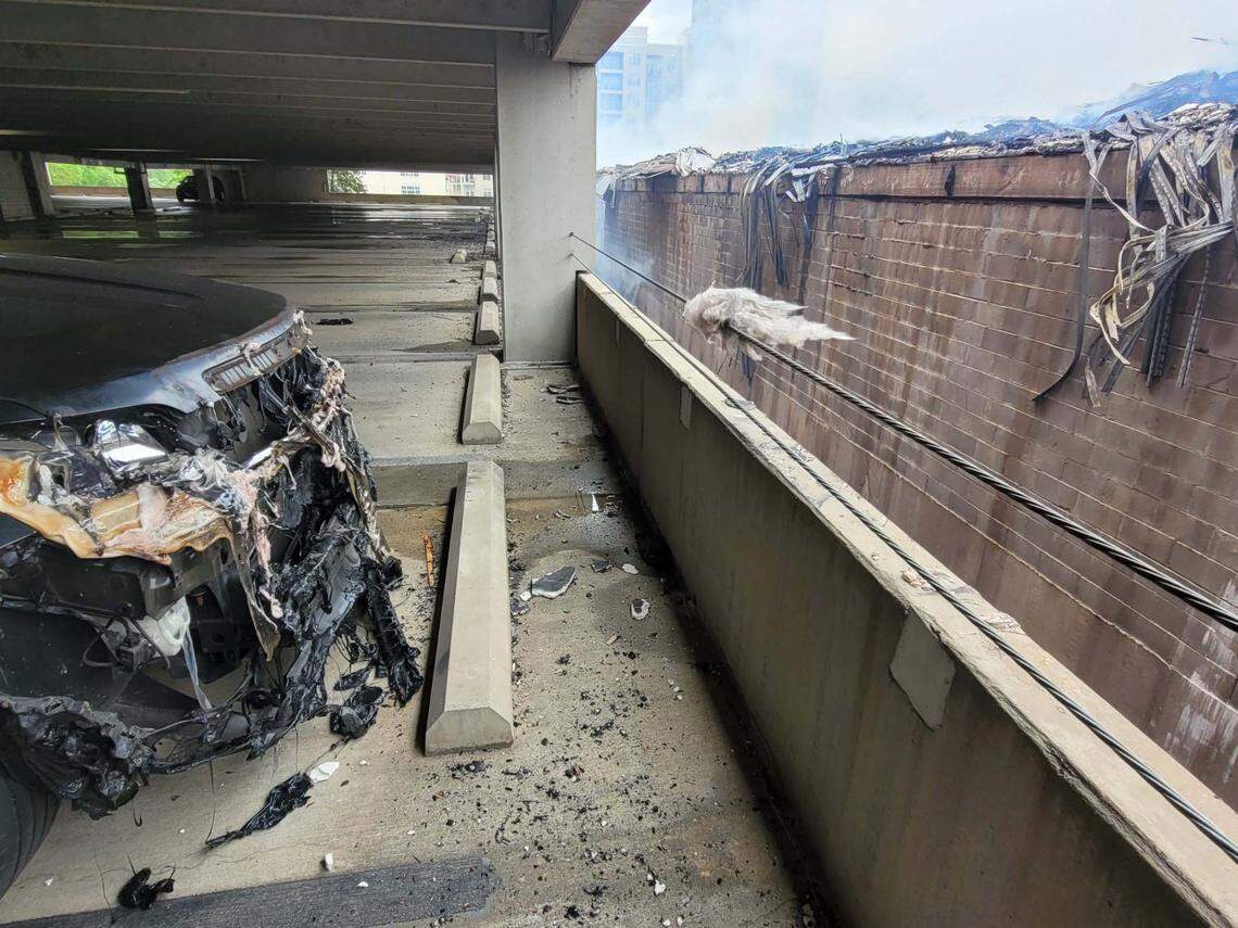 A bumper of a parked vehicle is damaged from the heat of a fire in Charlotte’s South Park neighborhood Thursday morning.