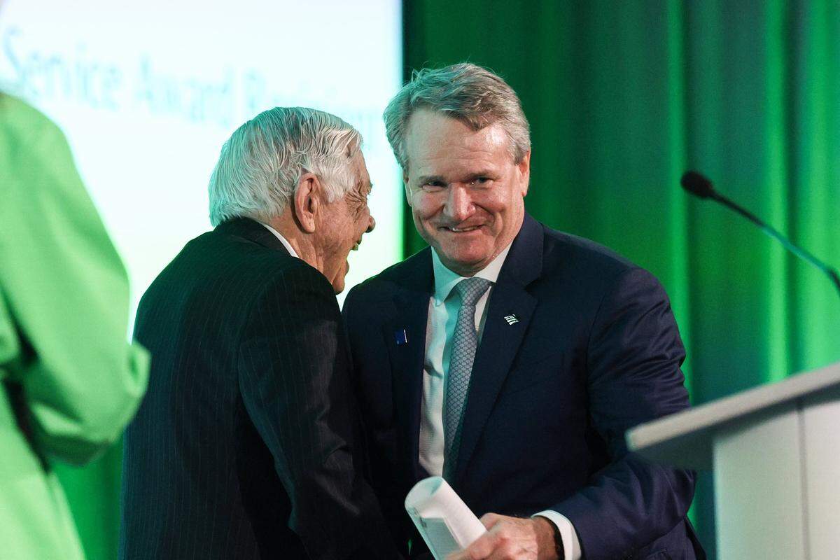 Hugh McColl, former CEO of Bank of America, left, greets Brian Moynihan, Chair and CEO of Bankof America as he approaches the stage to be honored with the Distinguished Service Award at UNC Charlotte on Monday, March 30, 2026.