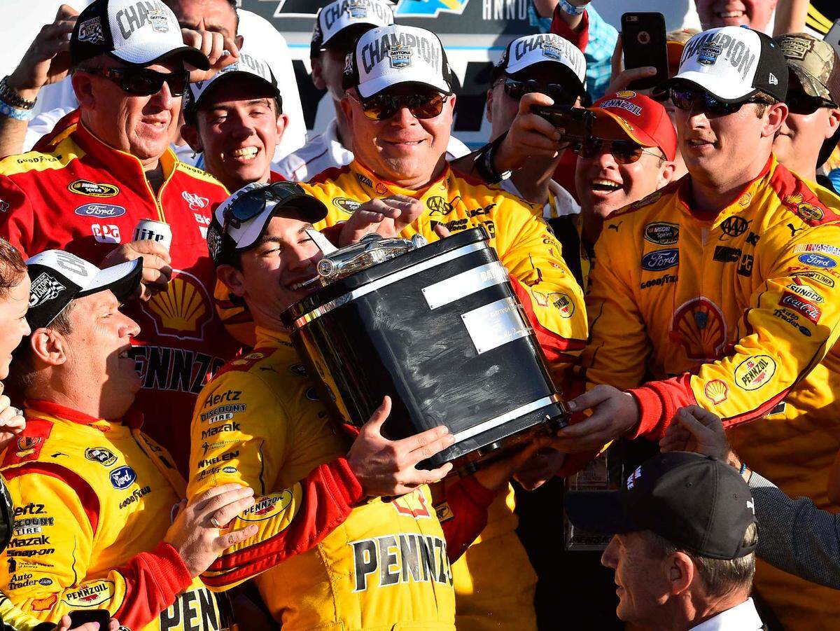 Feb 22, 2015; Daytona Beach, FL, USA; NASCAR Sprint Cup Series driver Joey Logano (22) lefts the Harley J. Earl Trophy after winning the Daytona 500 at Daytona International Speedway. Mandatory Credit: Jasen Vinlove-USA TODAY Sports