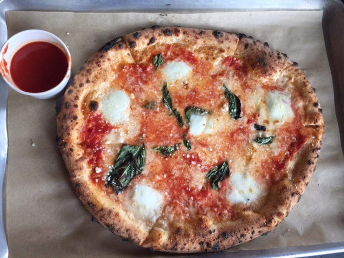 Inizio's version, with a beautifully freckled crust, comes with a little cup of marinara on the side.