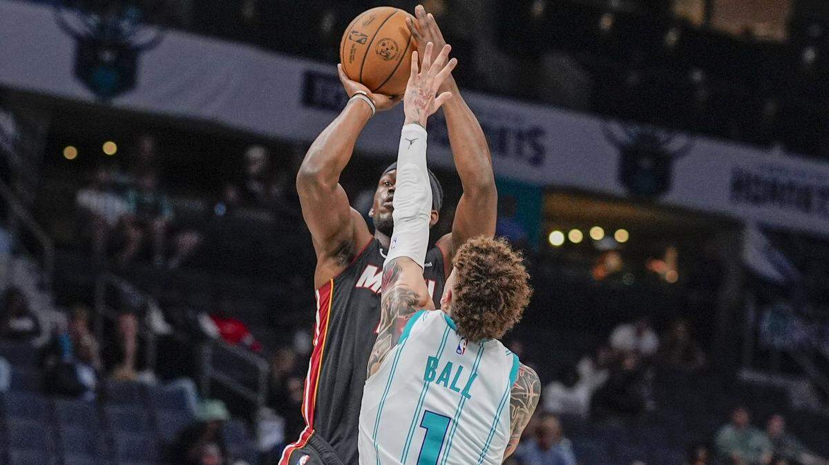 Miami Heat forward Jimmy Butler (22) shoots over Charlotte Hornets guard LaMelo Ball (1) during the first quarter at Spectrum Center.