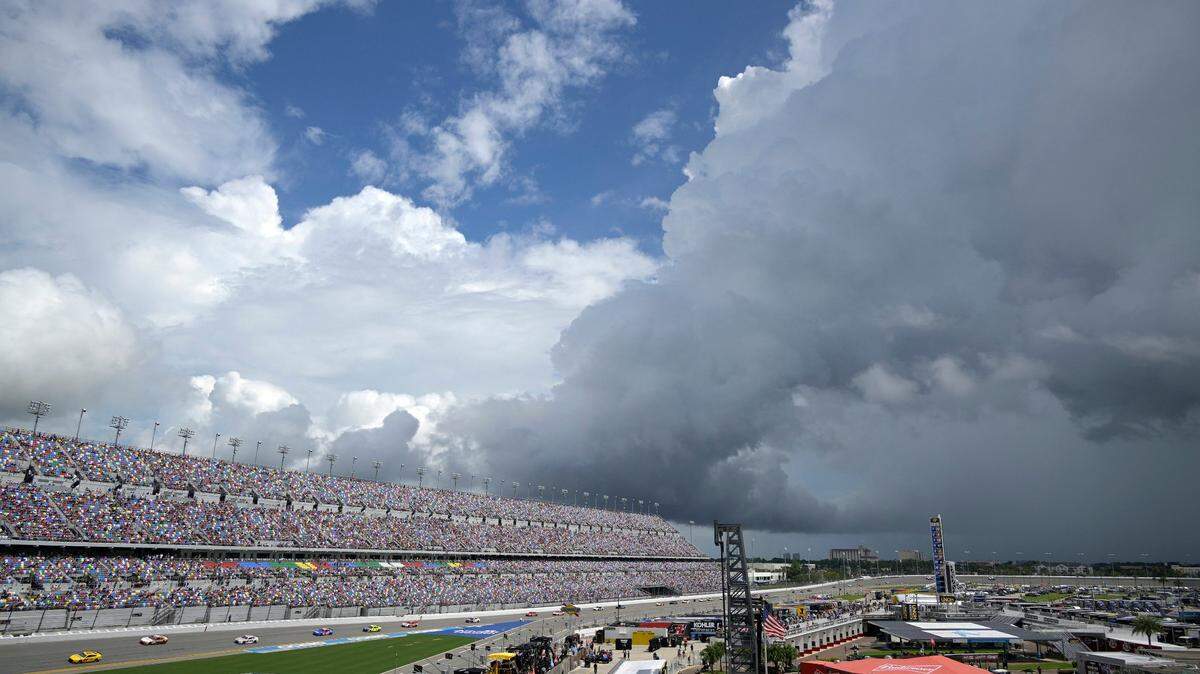 Drivers pass the front stretch during a caution flag, as thunderstorms approach the track during a NASCAR Cup Series auto race at Daytona International Speedway, Sunday, Aug. 28, 2022, in Daytona Beach, Fla. (AP Photo/Phelan M. Ebenhack)
