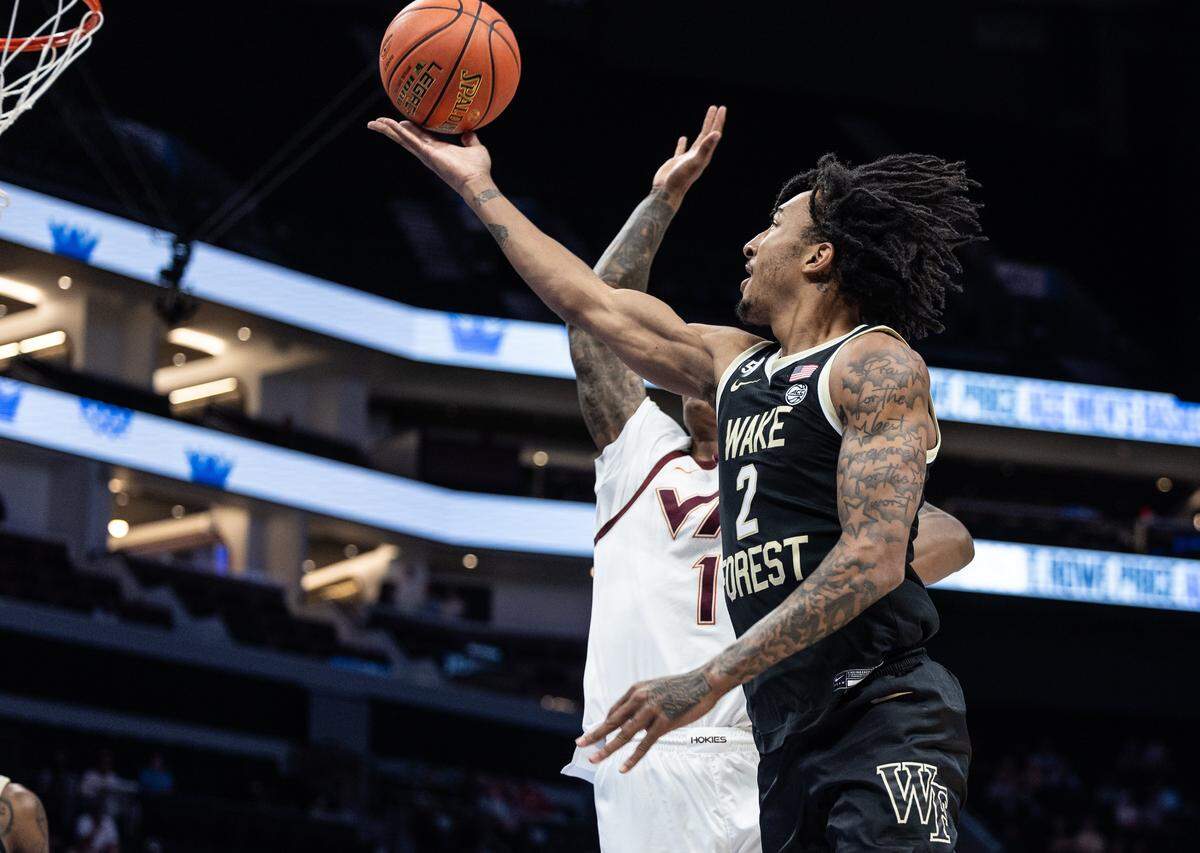 Wake Forest Demon Deacons guard Juke Harris, front, shoots past Virginia Tech Hokies forward Tobi Lawal during the ACC men's basketball tournament in Charlotte, N.C., on Tuesday, March 10, 2026.