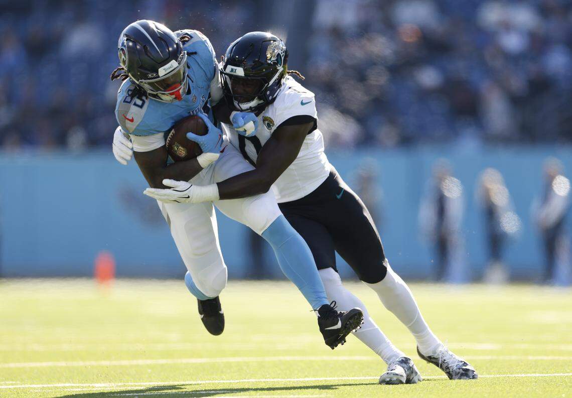 Jacksonville Jaguars linebacker Devin Lloyd tackles Tennessee Titans tight end Chig Okonkwo during a November 2025 game at Nissan Stadium in Nashville.
