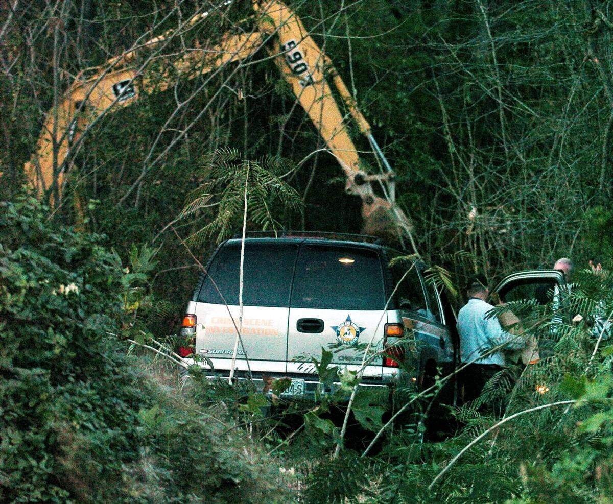 An officer from Cleveland County Sheriff loads brown evidence bags into a police vehicle at the crime scene where investigators have been digging for possible human remains off Rube Spangler Road in Lawndale, Cleveland county on Nov. 10, 2004.