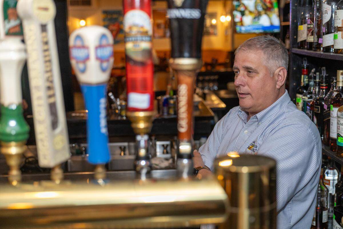 Owner Andy Hollis tends the bar at Sir Edmond Halley’s.