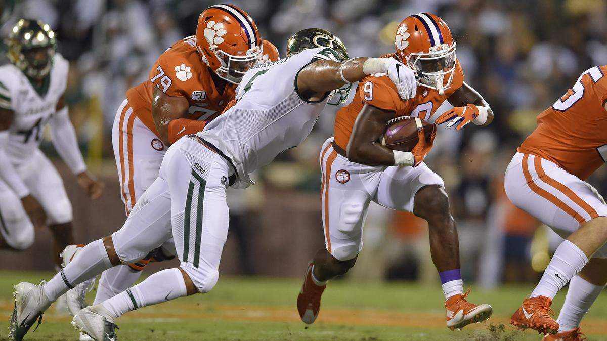 Clemson’s Travis Etienne, right, rushes out of the tackle of Charlotte’s Alex Highsmith, with blocking help from Jackson Carman (79) during the first half of an NCAA college football game Saturday, Sept. 21, 2019, in Clemson, S.C. (AP Photo/Richard Shiro)