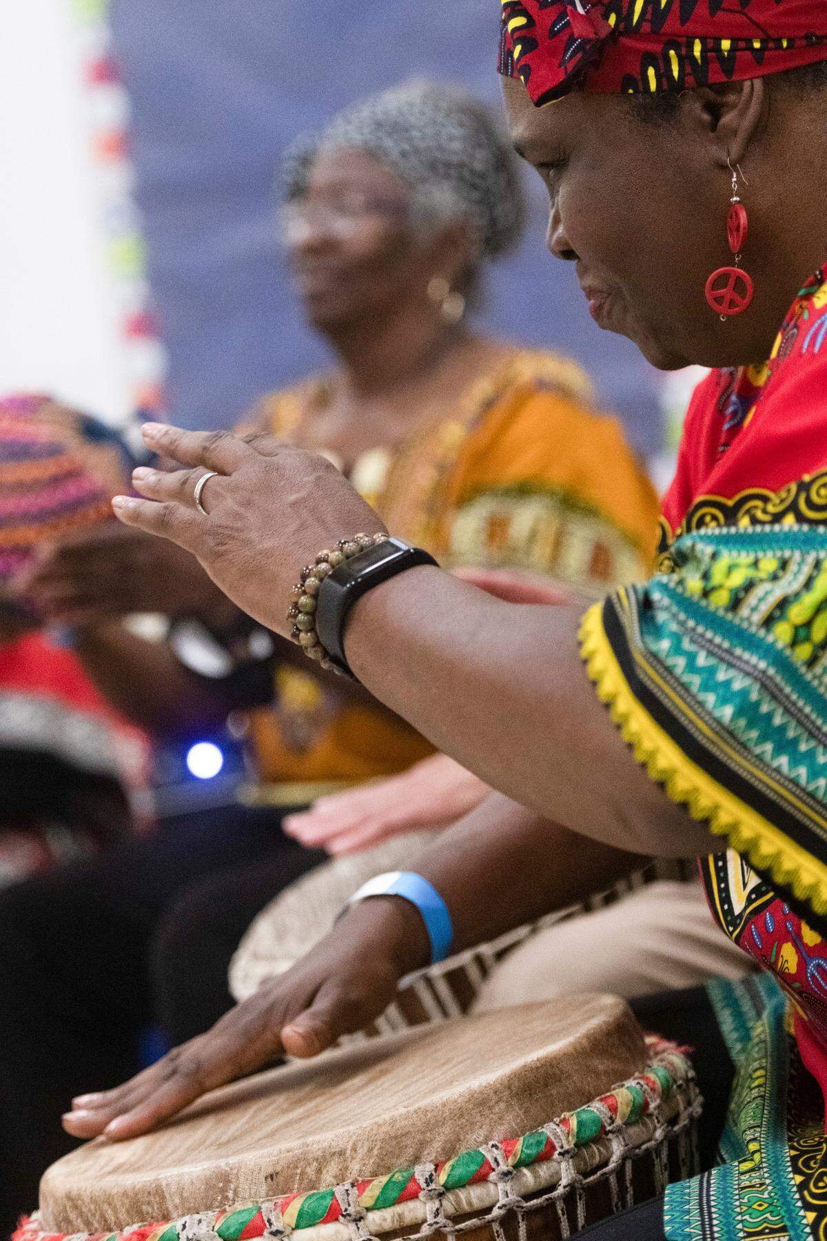Barbarette Talley, right, of the Queen City Senior African Drummers, plays the djembe alongside several drummers during the Juneteenth Festival of the Carolinas culture day camp at Elizabeth Traditional Elementary School in Charlotte, N.C., Thursday, June 16, 2022.
