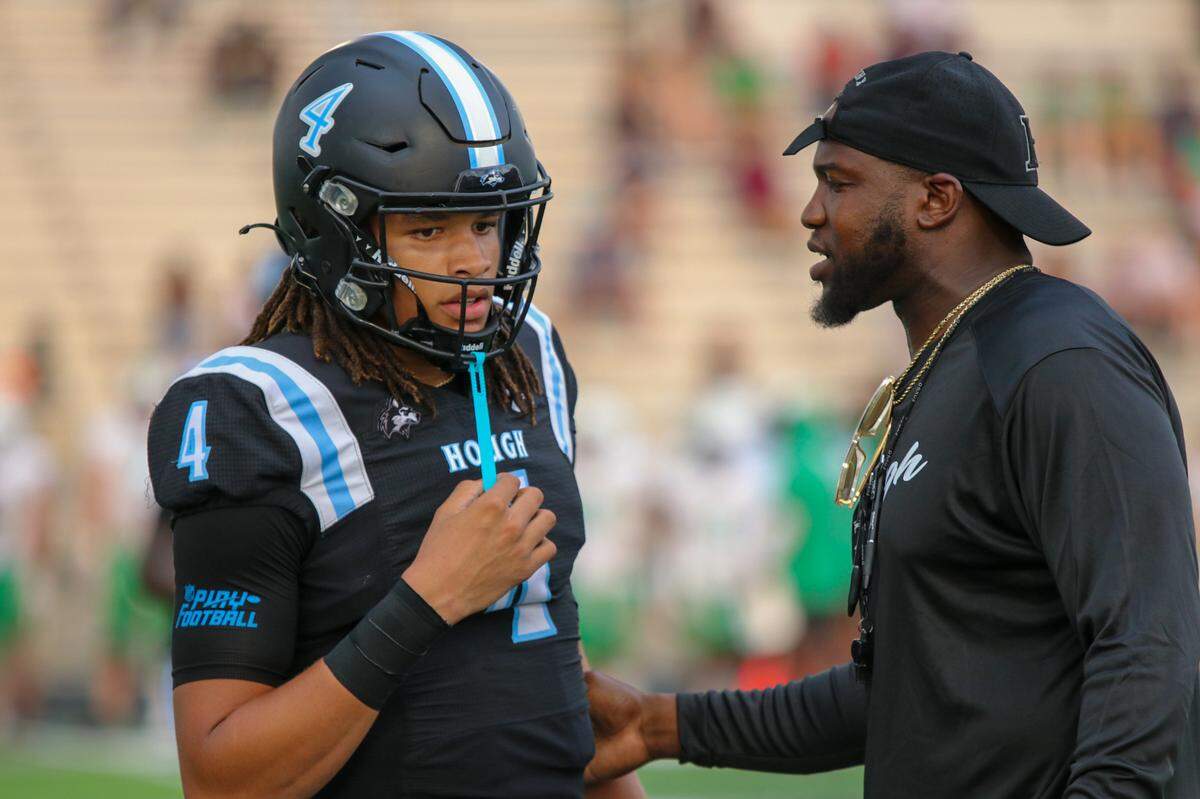 Hough quarterback Trey Blakeney chats with head coach Shawn Baker during Friday’s game with Myers Park