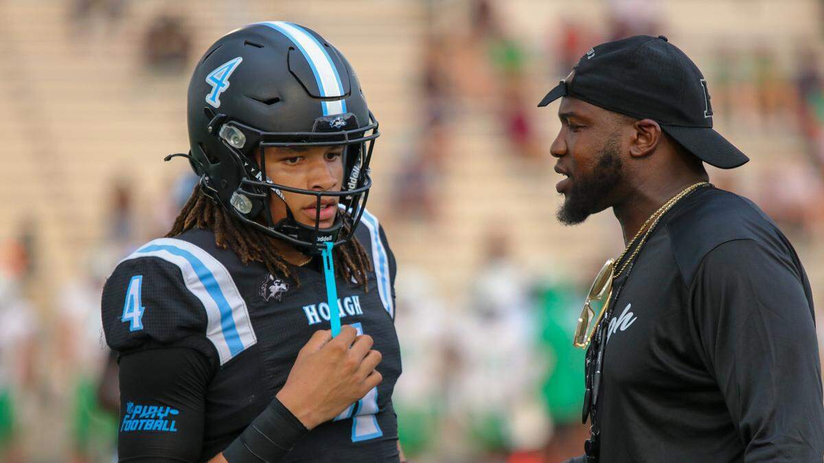 Hough quarterback Trey Blakeney chats with head coach Shawn Baker during Friday’s game with Myers Park