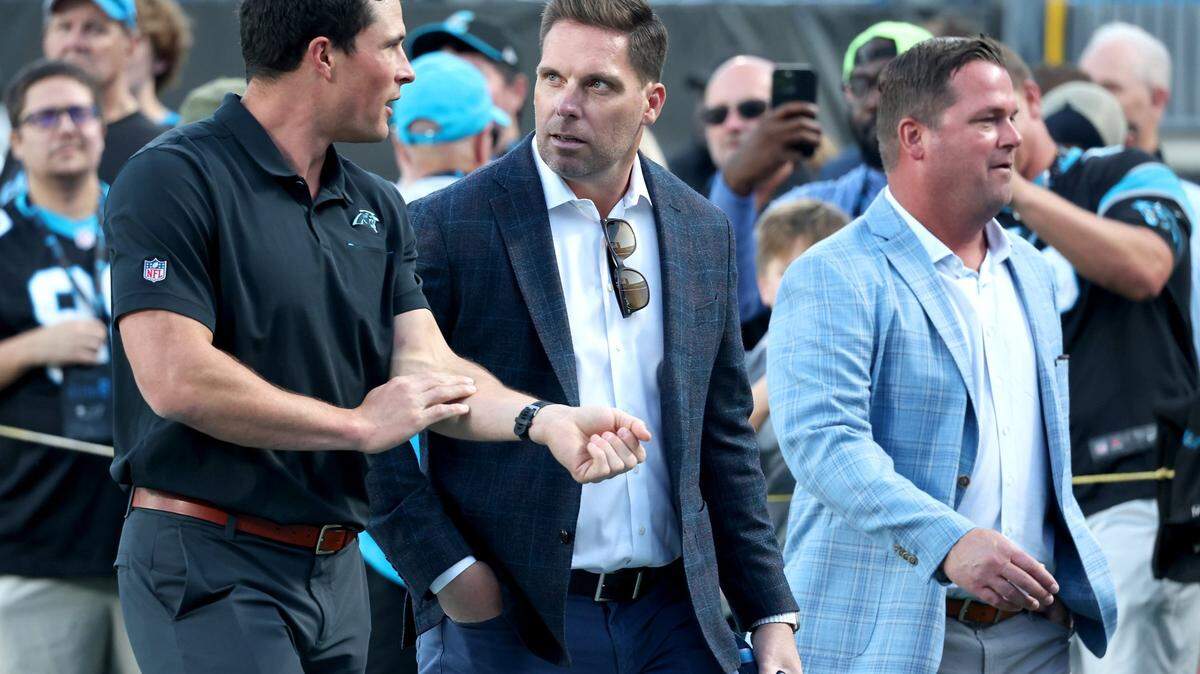 Former Carolina Panthers linebacker Luke Kuechly, left, speaks with Dan Morgan (center) in September. Morgan was named as the team’s new general manager Monday, replacing the fired Scott Fitterer (right).