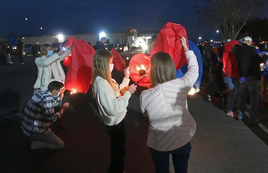 Family members and friends light prayer lanterns in honor of Jamie Seitz, the Lincoln Charter School teacher and coach who died of COVID-19 on Dec. 27th, during a memorial service at the school in Denver, NC on Dec. 30th.
