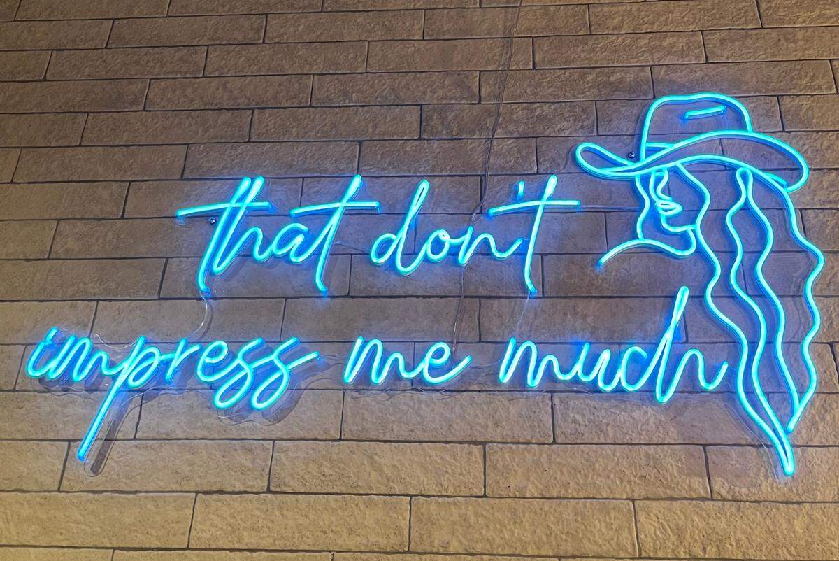 A neon Shania Twain lyric lights up a wall at Nickyo’s Rodeo.