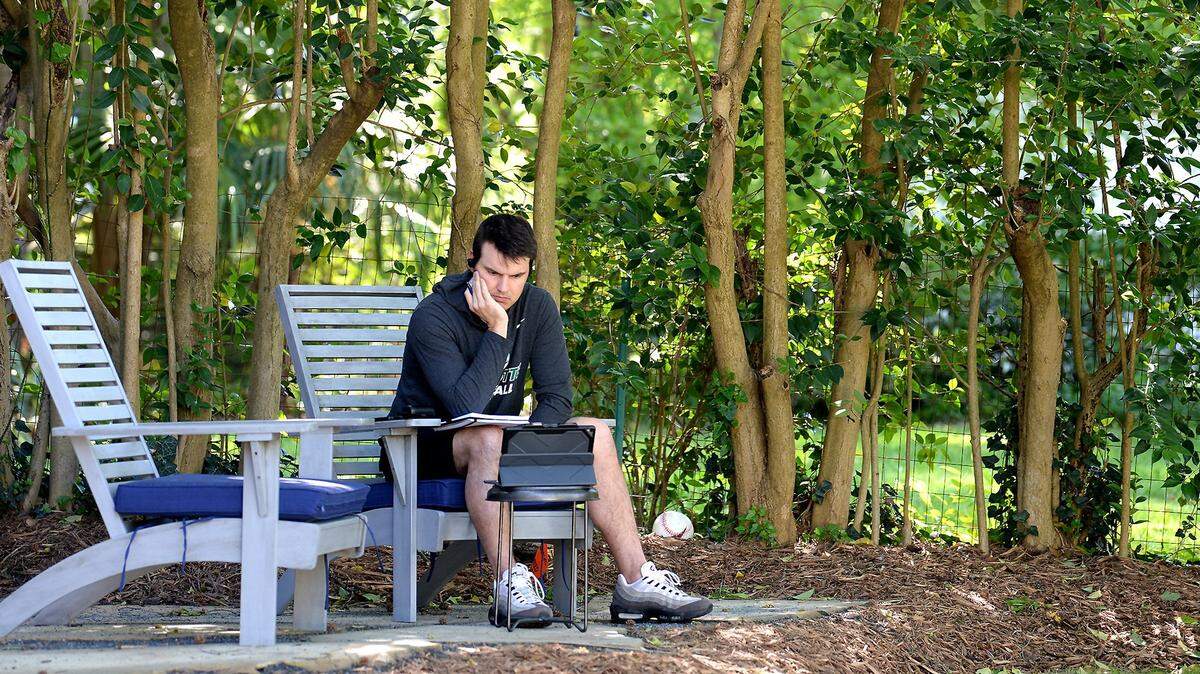 Charlotte 49ers head football coach Will Healy sits in his backyard listening to a conference call with Conference USA on Tuesday, April 14, 2020.