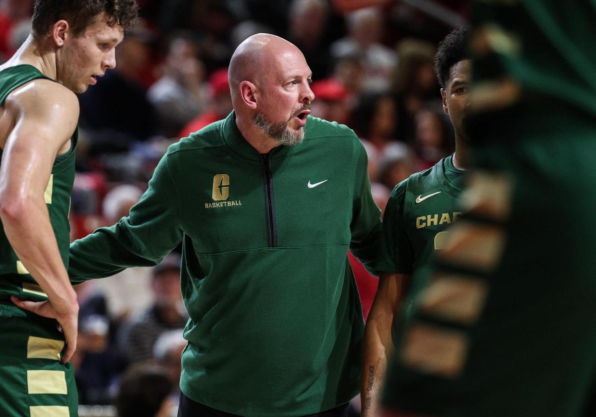 Charlotte head coach Aaron Fearne talks to players before a free throw attempt during a 2024 game against Davidson at Belk Arena.