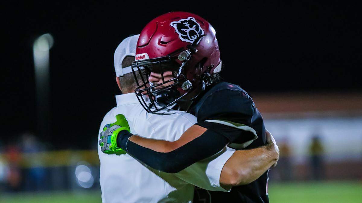 Bunkers hill players embrace with their coach as they keep their winning record