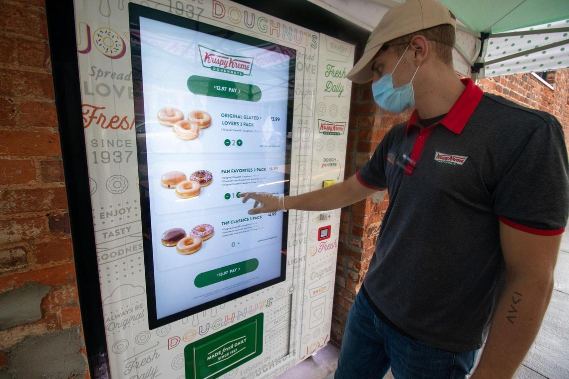 South End Krispy Kreme GM Luke Duffey demonstrates how to use the doughnut vending machine.